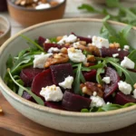 A beautifully styled Balthazar beet salad on a kitchen counter, surrounded by fresh ingredients and a bowl of vinaigrette.