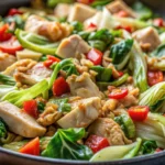 A family enjoying a meal of Hmong cabbage and chicken, with bowls of rice, fresh herbs, and a colorful table setting, showcasing the dish’s cultural and communal appeal.